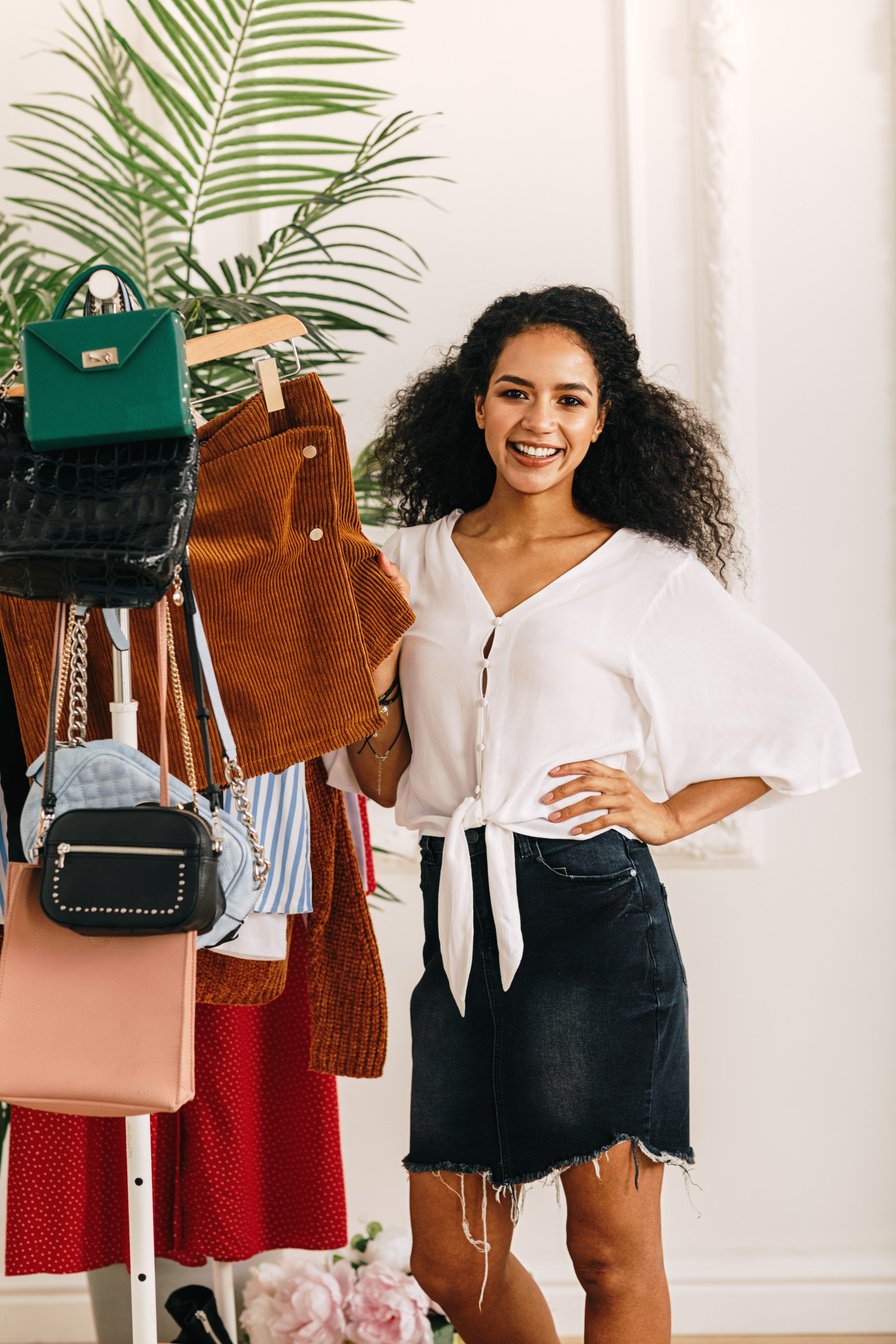 Fashion stylist posing at clothes rack